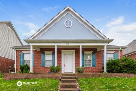 a red brick house with blue shutters and a white door