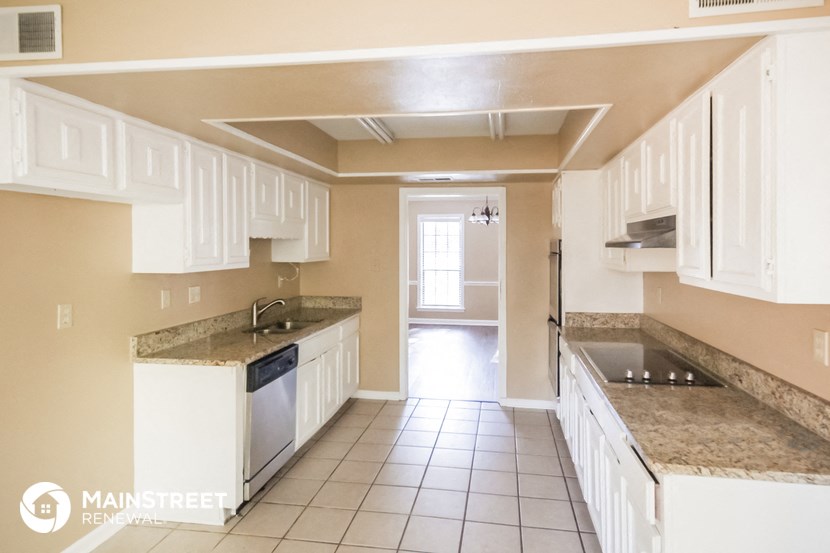 a kitchen with white cabinets and granite counter tops and white appliances