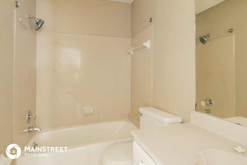 a white bathroom with a tub and a toilet and a sink