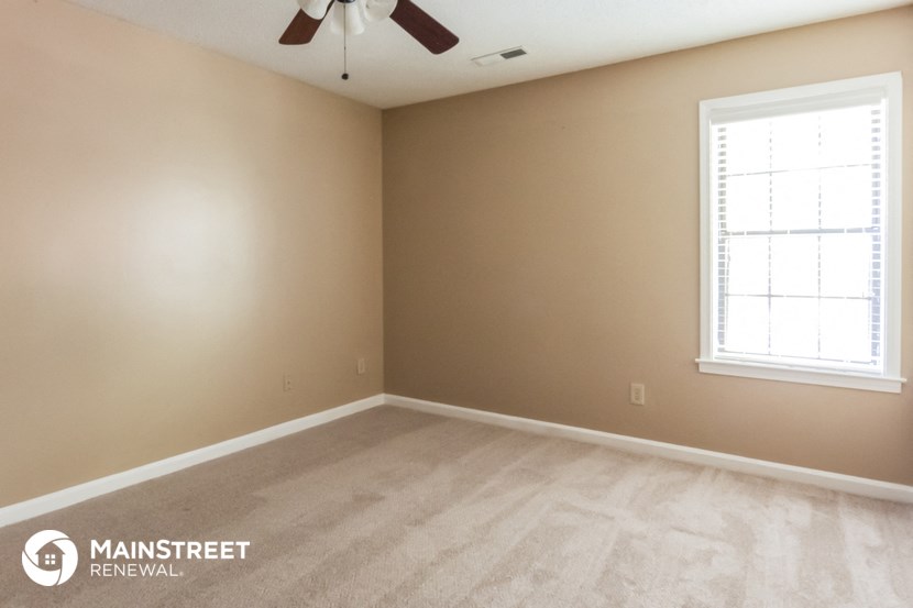 an empty room with a ceiling fan and a window