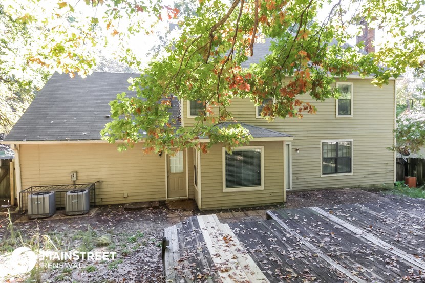 the back of a house with a yard and a deck