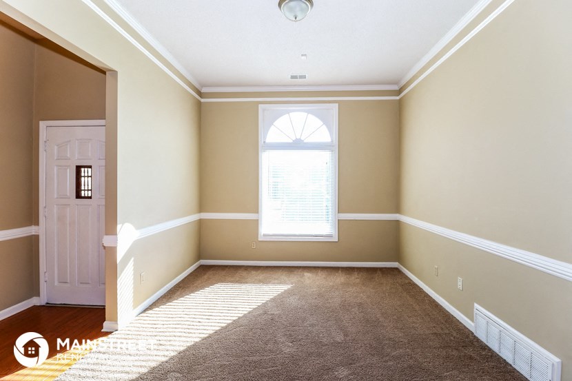 an empty room with a white door and a window