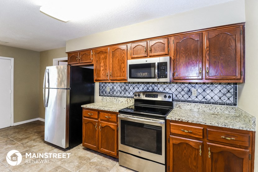 a kitchen with wooden cabinets and stainless steel appliances