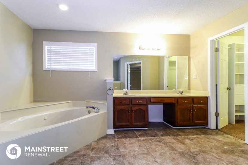 a bathroom with a tub and a sink and a mirror