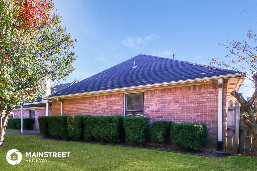 the front of a brick house with a blue roof