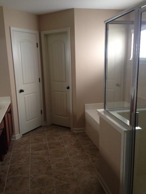 a bathroom with a shower and a sink and a door