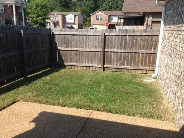 a backyard with a fenced in area and a fence