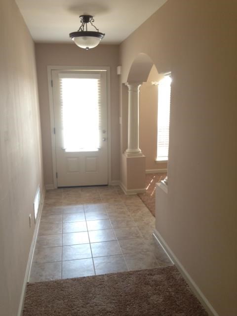 a hallway with a tile floor and a white door