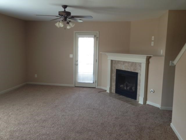 a living room with a fireplace and a ceiling fan