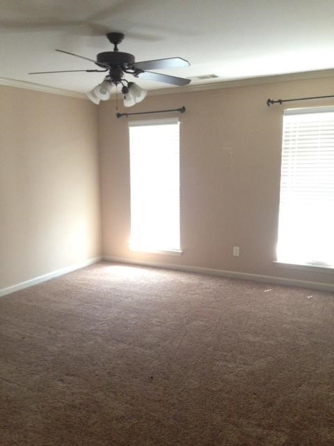 a living room with a ceiling fan and a window