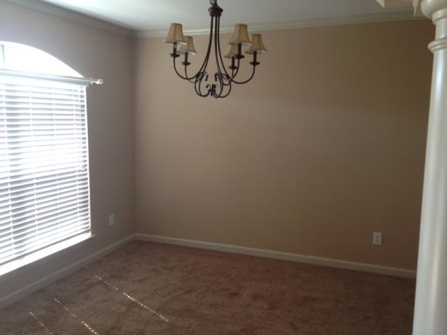 a dining room with a chandelier and a window
