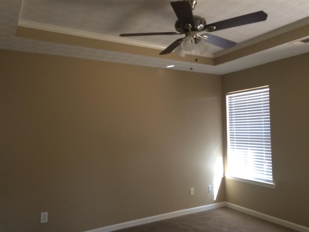 a living room with a ceiling fan and a window