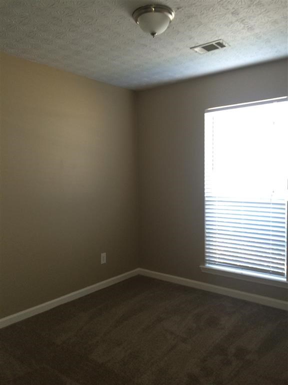 an empty room with a window and a ceiling fan