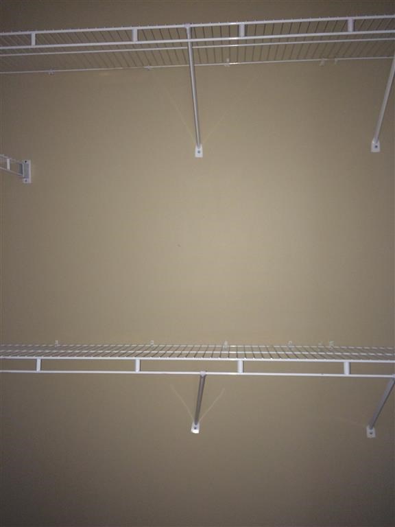 an empty closet with a wire rack on the wall