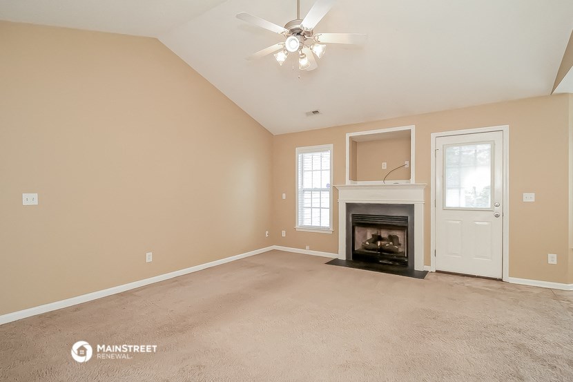 the living room with fireplace and ceiling fan