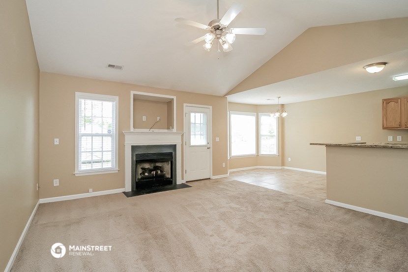a living room with a fireplace and a ceiling fan