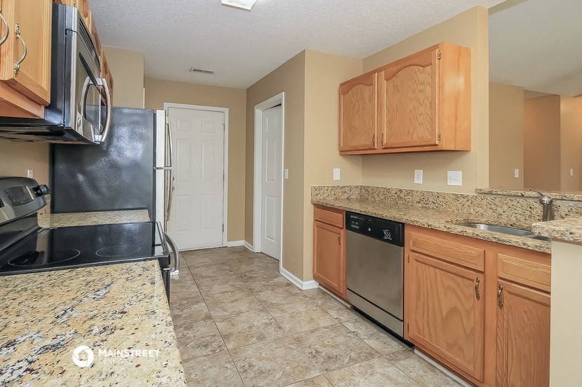 a kitchen with granite counter tops and black appliances