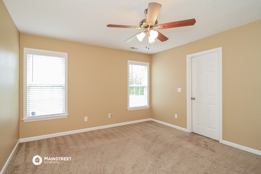 the master bedroom has a ceiling fan and a carpeted floor