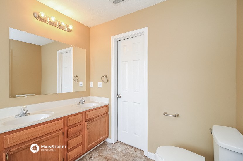 a bathroom with a toilet and a sink and a mirror