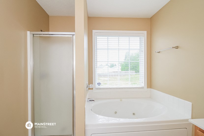 a bathroom with a tub and a shower and a window