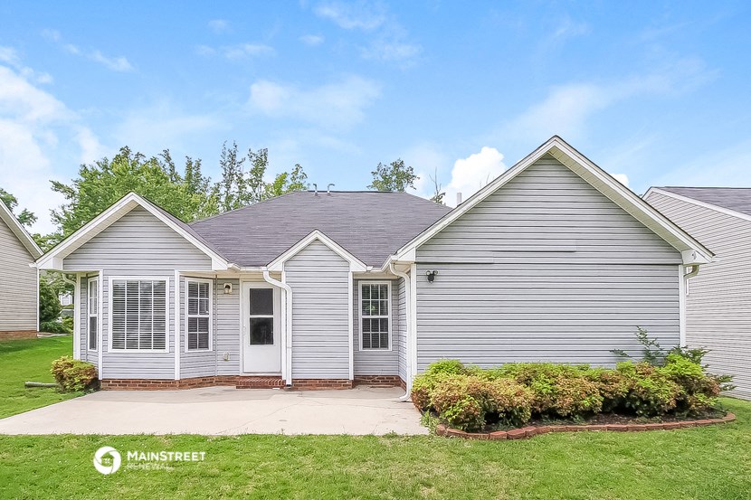 a small gray house with white siding and a lawn