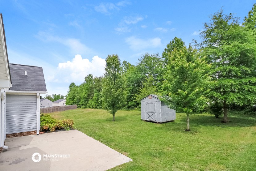 a backyard with a shed and a yard with trees