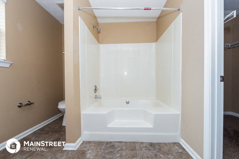 the master bathroom has a large tub and a shower