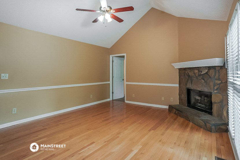 a living room with a fireplace and a wooden floor