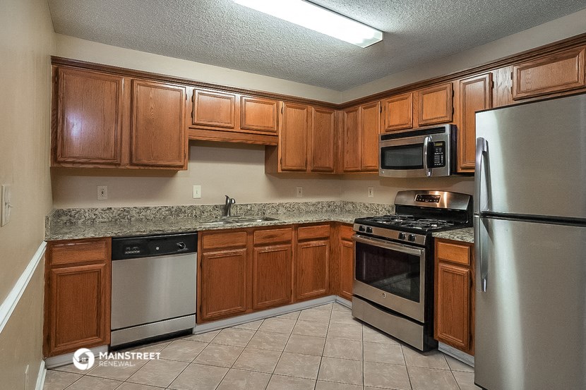 a kitchen with wooden cabinets and stainless steel appliances