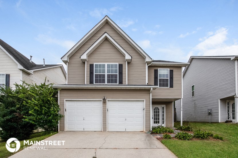 a tan house with a white garage door