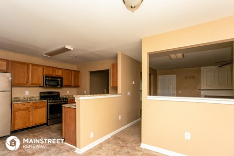 a kitchen with wooden cabinets and appliances and a large window