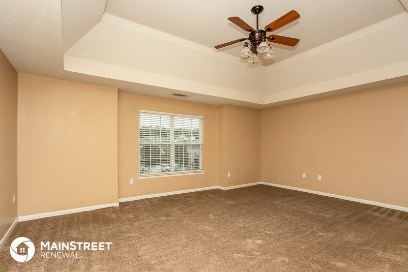 a living room with a ceiling fan and a window