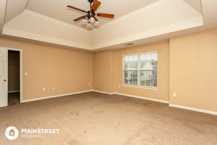 the master bedroom has a coffered ceiling and a large window