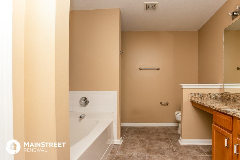 a bathroom with a tub and a sink and a toilet