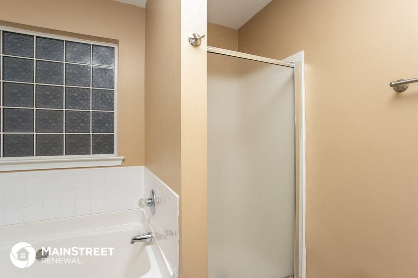 a bathroom with a tub and a shower and a window