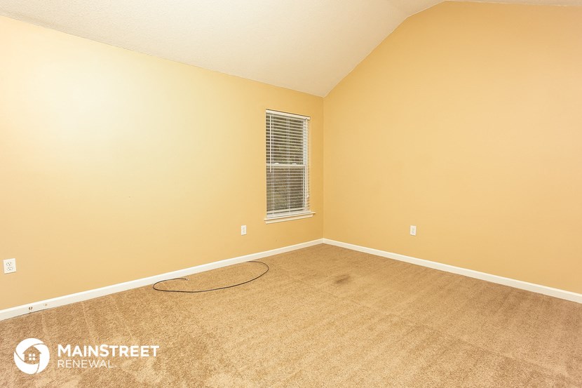 a carpeted room with a cord on the floor