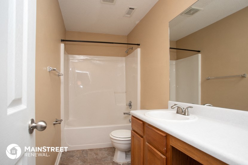 a bathroom with a shower toilet and sink and a mirror