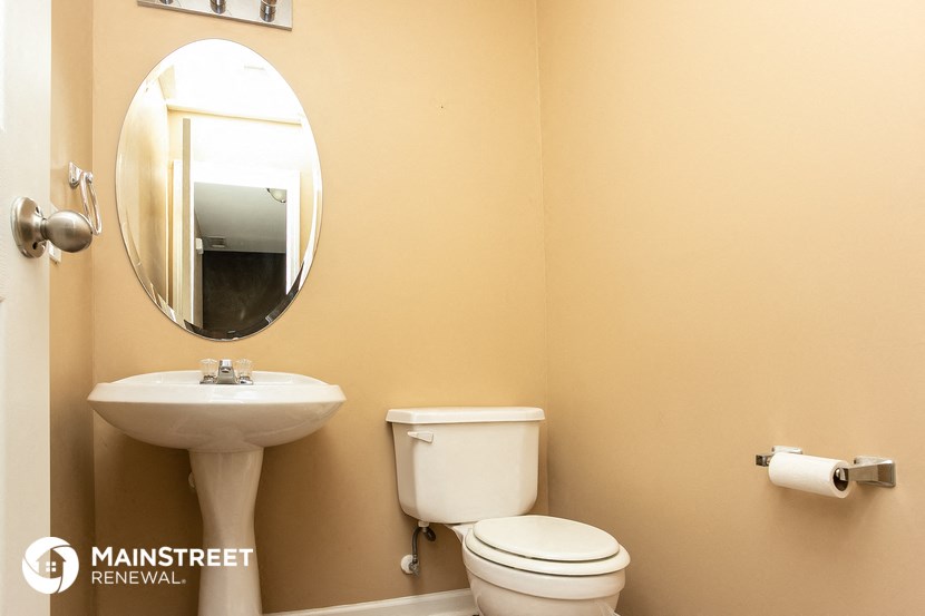 a bathroom with a toilet and a sink and a mirror