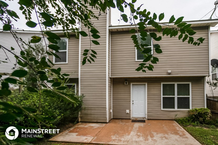 the front of a house with a driveway and a white door