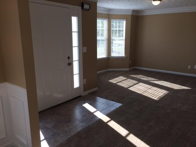 an empty living room with a door and windows