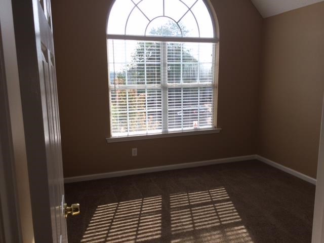 an empty room with a large window and a door