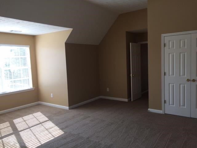 an empty room with a white door and a window