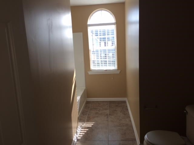 a small bathroom with a window and a toilet