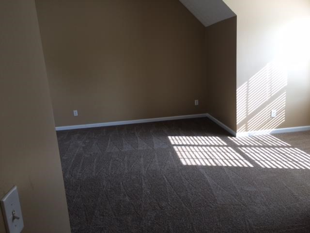 an empty living room with sunlight coming through a window