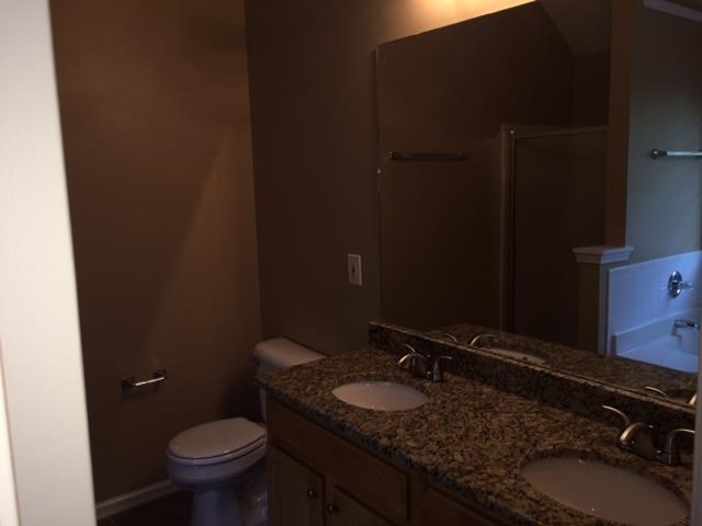 a bathroom with two sinks and a toilet