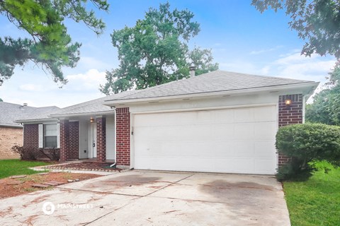 a white garage door in front of a brick house