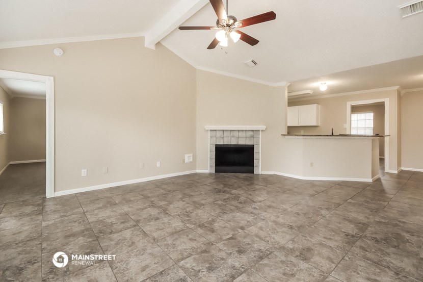the living room with fireplace and tile flooring and a ceiling fan