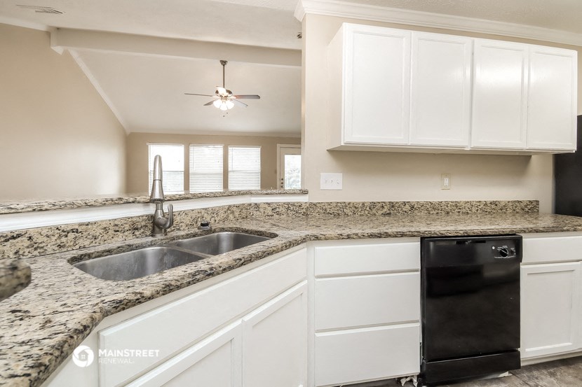 a kitchen with white cabinets and granite counter tops