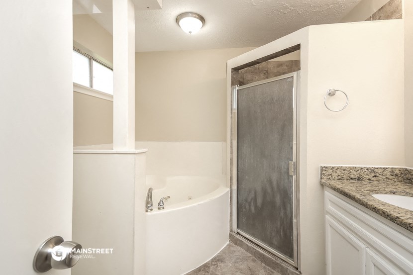 a bathroom with a tub and a shower and a sink