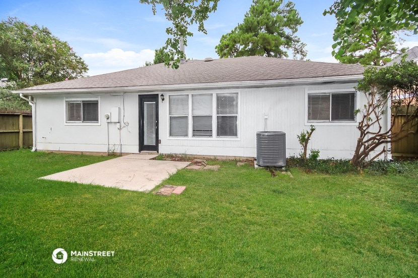 a white house with a yard and a backdoor